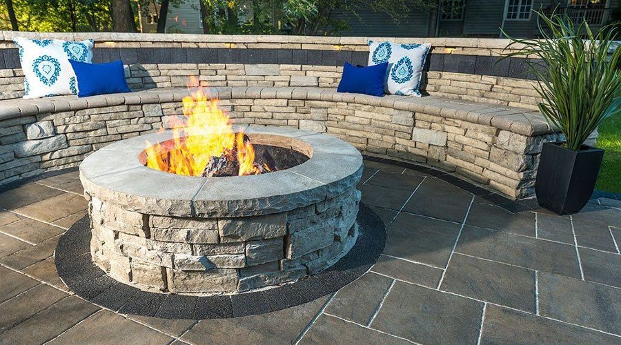 Firepit and Hardscape wall with bench built into. Fire in fire pit
